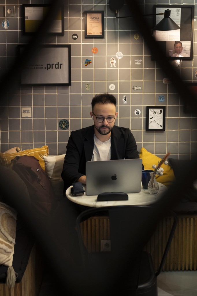Álvaro working on a laptop in a café