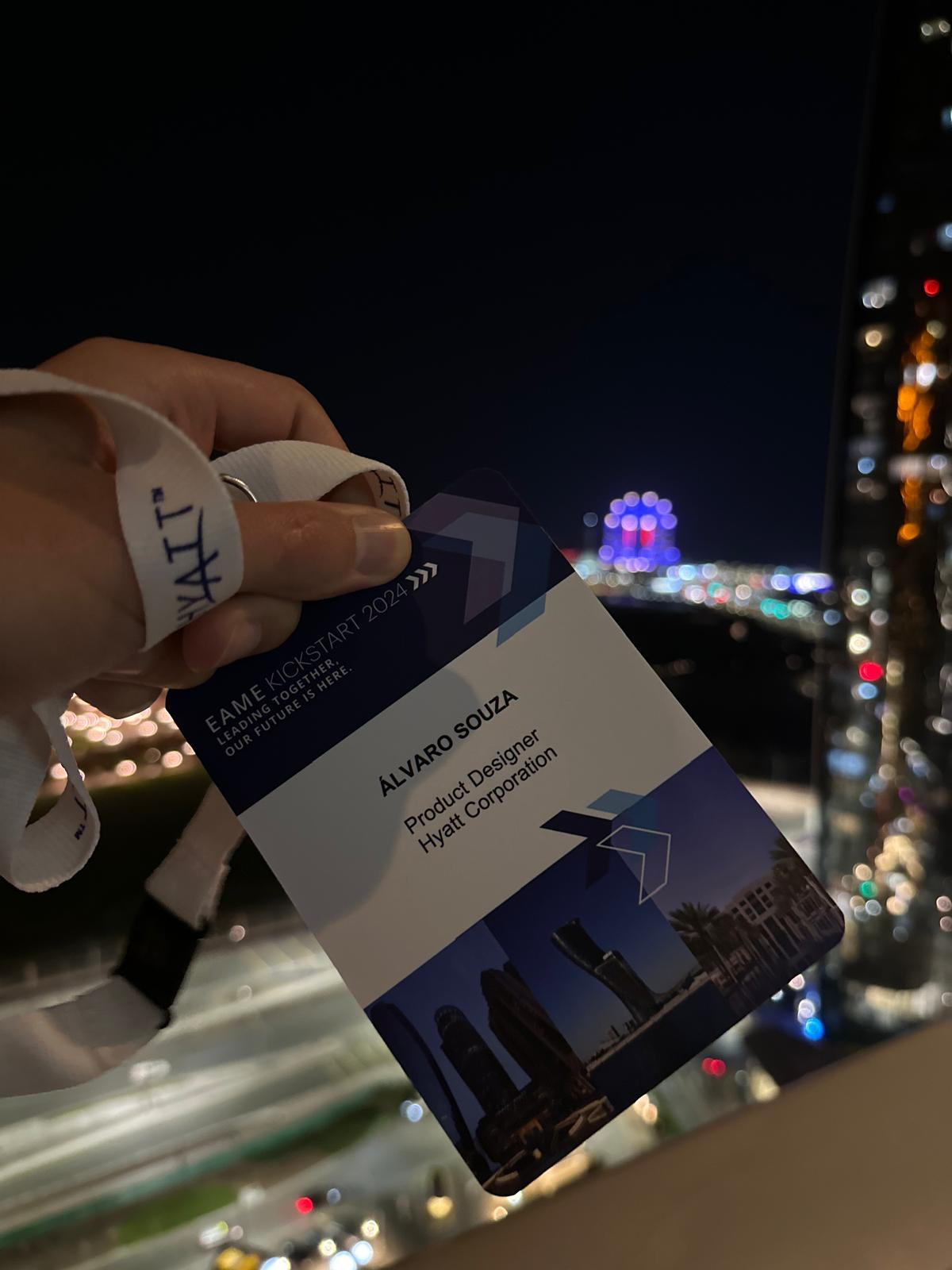 Álvaro's Hyatt badge at the EAME Kickstart event, city lights at night behind